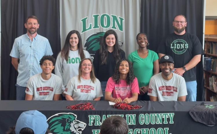 Lexi Knox (seated center) was joined for a celebration of the signing of a track scholarship with North Greenville University by (front, from left) brother Jeromyah Knox, mom Heather Knox, dad Shon Knox, (back) and coaches Aaron Campbell, Megan Jackson, Allie Shubert, Ann Bowman and Josh Bentley.