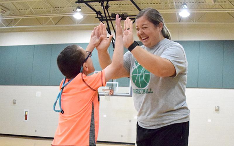 Tripp Witherell gives Amber Adams high tens during physical education class at Carnesville Elementary School. He is one of the students Adams is working with in the Adaptive PE program. (Photo by Sinclair)