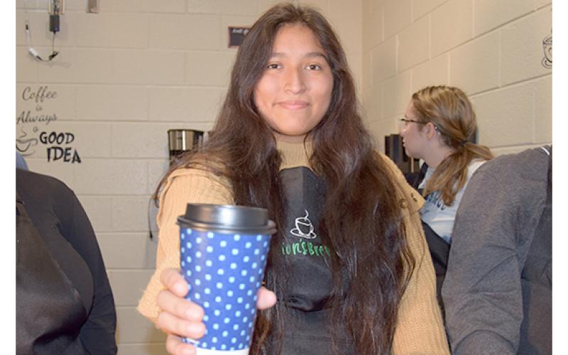 Jennifer Sigala hands out a cup of coffee in the Lion's Brew, a new coffee shop that will open Nov. 16 at Franklin County High School. (Photo by Sinclair)