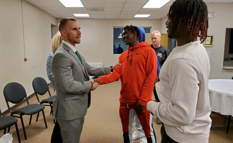 New Franklin County Lion head football coach Parker Martin (left) talks with Fredricus Oglesby  (center) and Josh Butler (right) during a meet and greet Tuesday after being officially hired by the Franklin County Board of Education. (Photo by Sinclair)