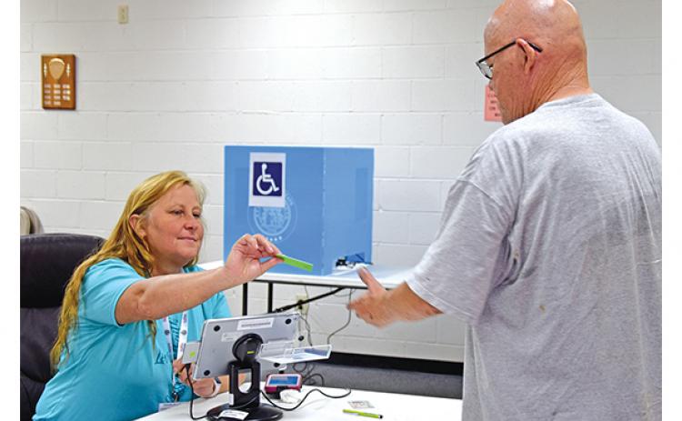 Poll worker Teresa Swing checks in Carl Whitworth to vote in Canon’s special election on Tuesday afternoon. (Photo by Sinclair)
