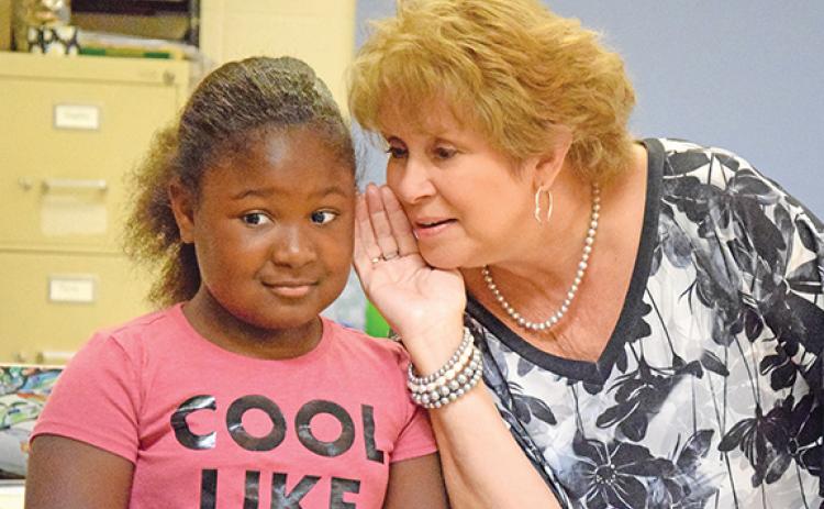 Royston Elementary teacher Regina Corn shares a secret with Amiracle Roebuck — she has board games hidden in her third grade classroom. (Photo by Sinclair)