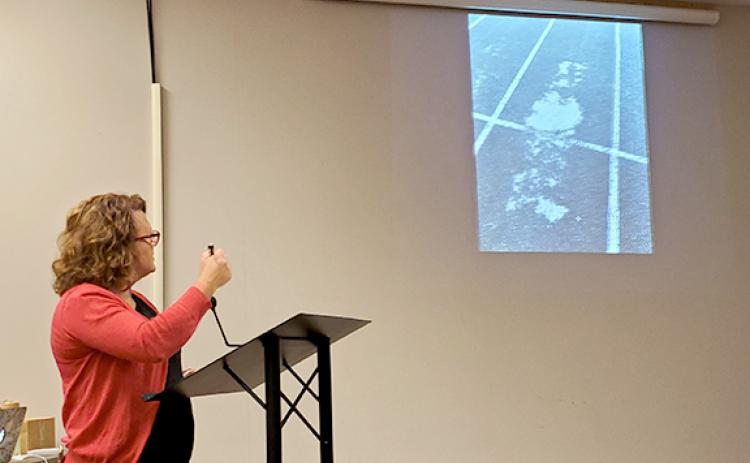 Renee Duncan shows Franklin County Board of Education members a worn part of the track at Franklin County High School. “You can’t invite people and can’t be proud of that,” Duncan said. (Photo by Sinclair)