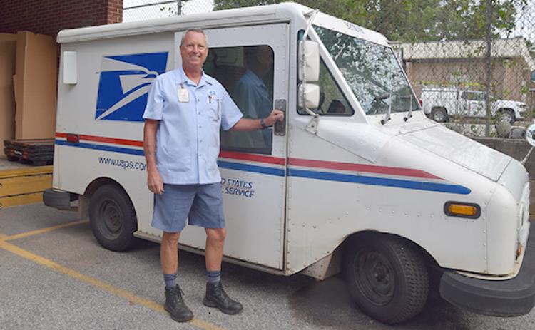 Mike Floyd stands in front of his mail truck before starting his route on his last day. (Photo by Sinclair)