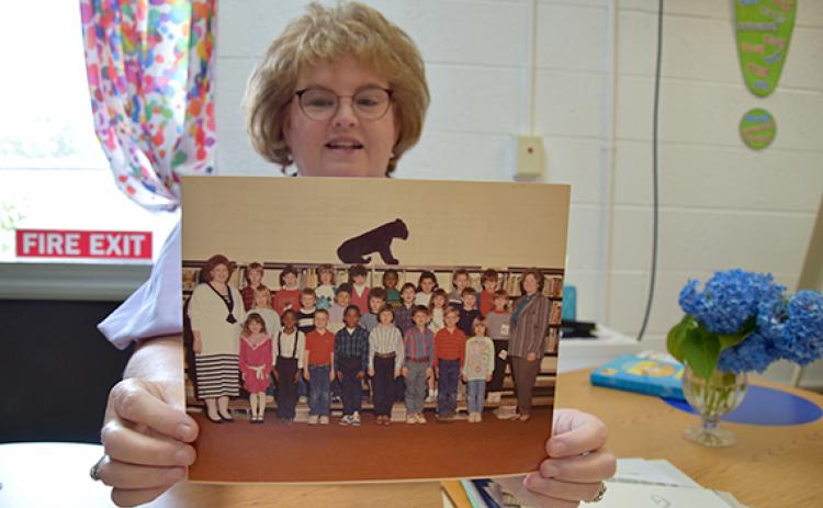 As she goes through her “forever file,” Robyn Moon finds the photo of the 28 “babies” in her first class of first graders. (Photo by Sinclair)