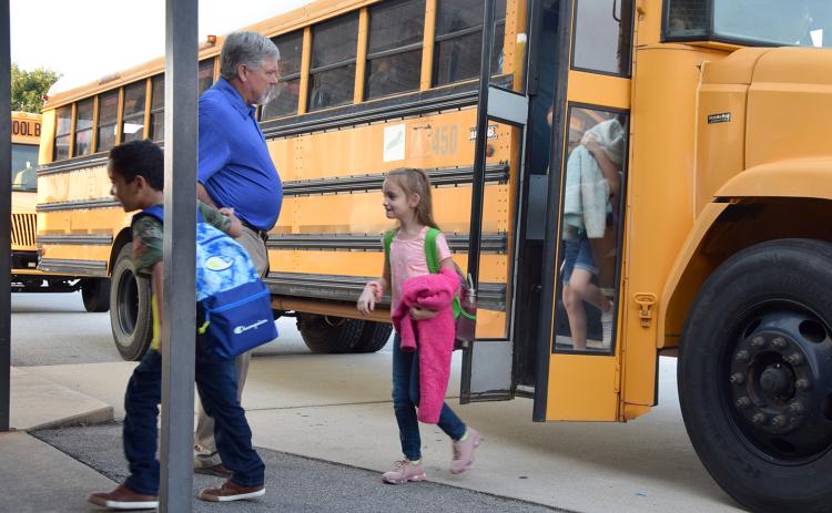 Lavonia Elementary School Principal Brad Roberts welcomes students as they get off the bus on the first day of school Friday. (Photo by Sinclair)
