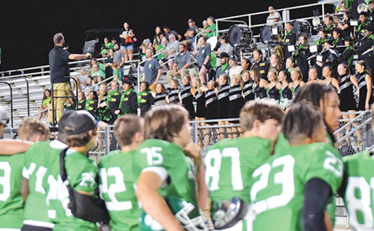 The Lions football players listen as the Franklin County Marching Pride Band plays the alma mater at Homecoming Friday night.