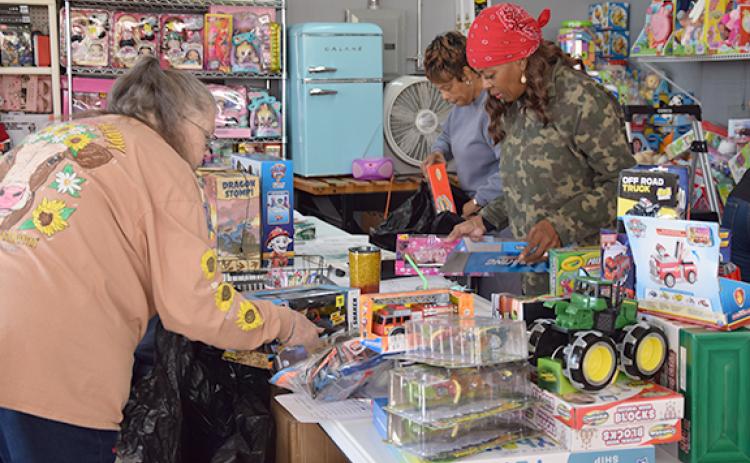 Gale Griffin, Katherine Fletcher and Dee Neal package toys for children in the Toys for Tots warehouse in Royston.