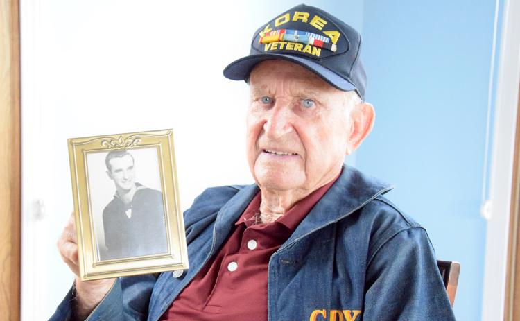 Roy Gandy holds a photo of himself during his time in the U.S. Navy. (Photo by Sinclair)