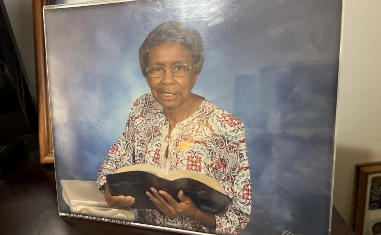 A photo in Geneva Butler’s home shows her with her Bible. Butler said her life motto is “Do what all I can for the Lord, while I can.” Reading her Bible is a favorite pasttime, she said. (Photo by Raese)