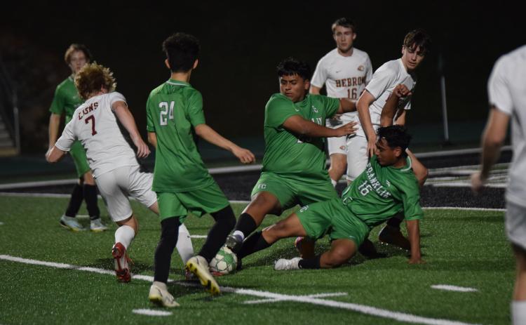 Franklin County Lion defenders Jorge Mendez (No. 24), Bryan Valle (No. 25) and Rodrigo Valle (No. 16) surround a ball near the goal in a game last week against Hebron Christian. (Photo by Scoggins)