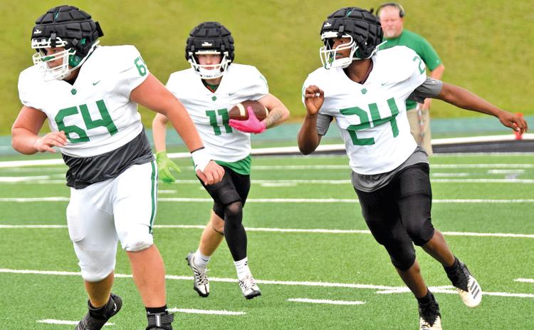 Colt Irvin (No. 64) and Jordan Ardister (No. 24) lead the way for White team back Jacob Thompson (No. 11) during a scrimmage Friday night. (Photos by Scoggins)