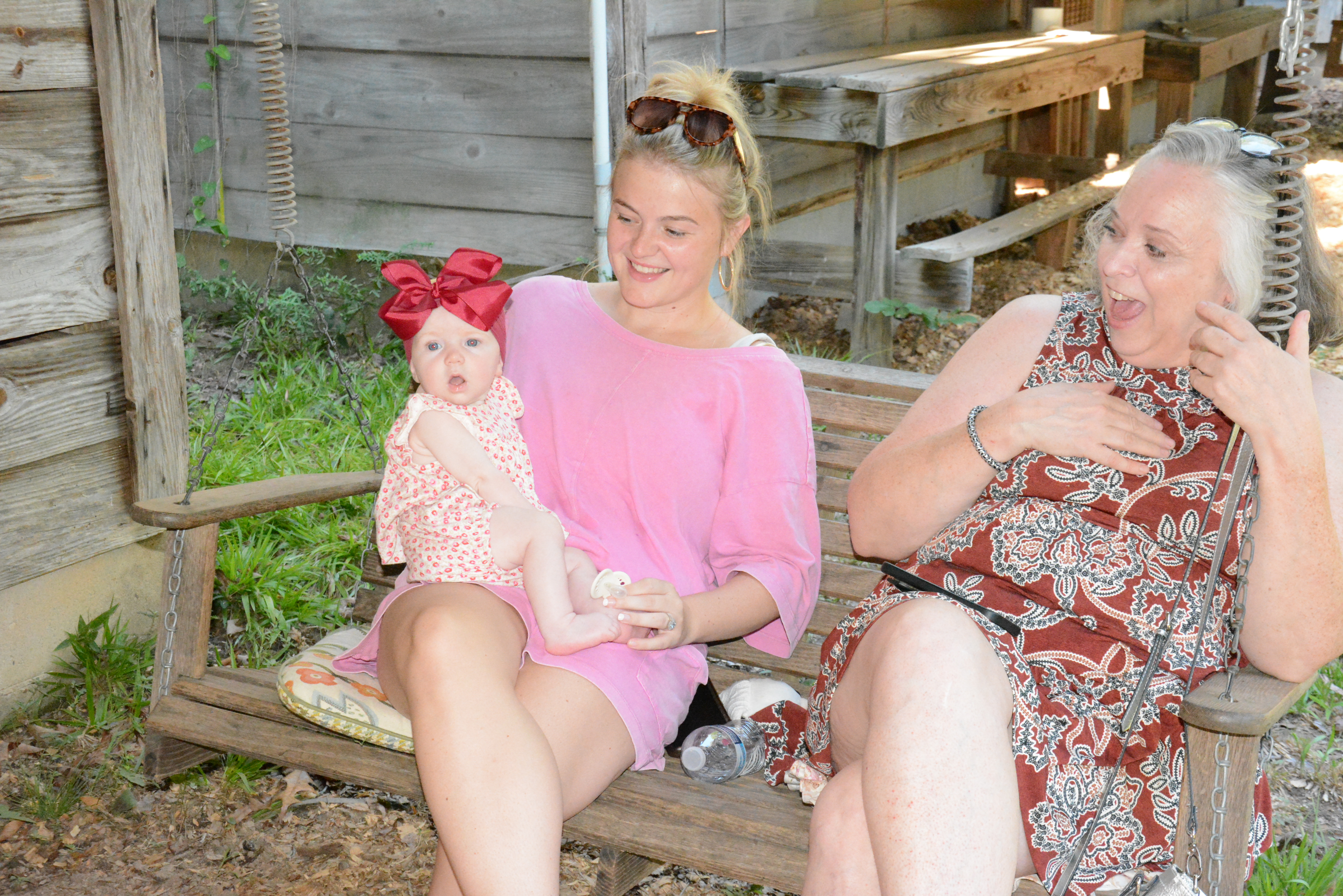 Rebecca Milford Floyd laughs at the antics of little Landrie Armour, who is being held by her mother Alyssa Ellard.