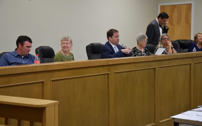 Franklin County Board of Elections and Registration members (from left) Roman Strickland, Alice Black, Chairman Doug Kidd, Sherry MacDonald and Angela Whidby (with County Attorney Bubba Samuels and Elections Superintendent Gina Kesler) prepare to listen to tesimony following a break in a hearing Wednesday on a challenge to the residency of Lee and Sheena Strickland.