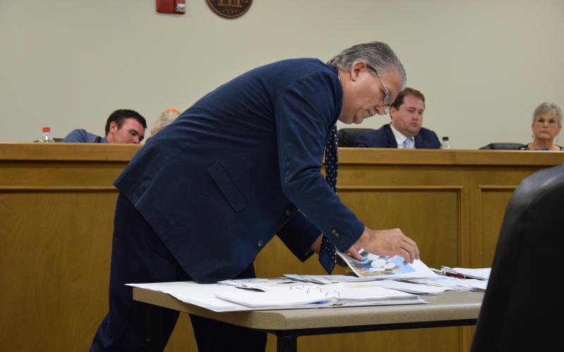 Royston City Council candidate Wesley Fricks thumbs through evidence during a hearing Wednesday on a challenge to the residency of Lee and Sheena Strickland.