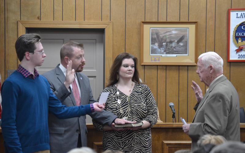 New Lavonia Mayor Courtney Umbehant (center on left), surrounded by son Noah and wife Natalie, takes the oath of office from outgoing Mayor Ralph Owens Monday during the Lavonia City Council’s first meeting of 2020. (Photo by Eberhardt)