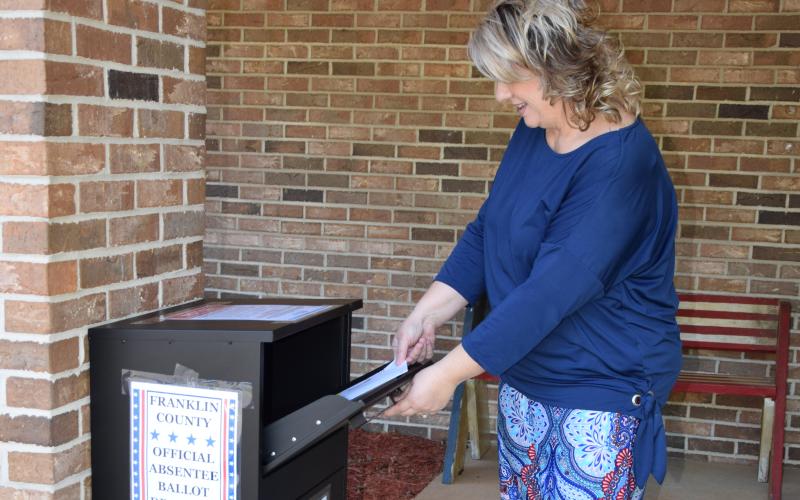 Franklin County Elections Supervisor Gina Kesler demonstrates how to drop off an absentee ballot at her office's new outside drop box that will be available for the June 9 primary.
