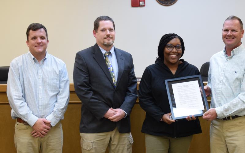 Raeshonda Thornton receives a framed copy of a resolution naming the gym at Rocky Ford Park in honor of her father, Michael Mayfield Sr. Franklin County Commissioners (from left) Robert Franklin, Kyle Foster, Chairman Jason Macomson, Eddie Wester and Ryan Swails approved the resolution Tuesday. (Photo by Scoggins)