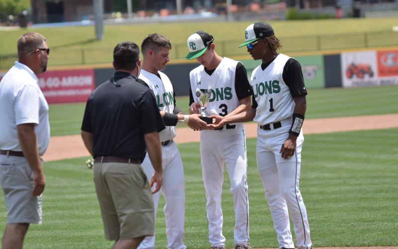Seniors Evan Herring, J.D. Ginn and C.J. Blackwell accept the state runner-up trophy Monday at CoolRay Field in Lawrenceville.