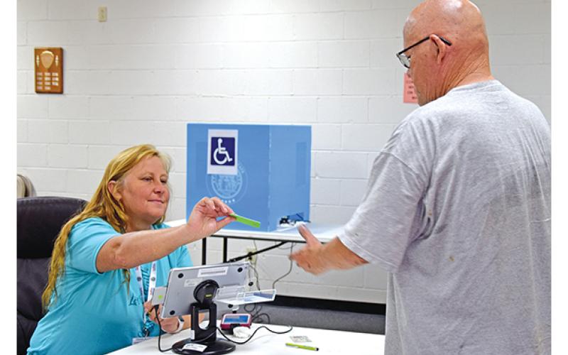 Poll worker Teresa Swing checks in Carl Whitworth to vote in Canon’s special election on Tuesday afternoon. (Photo by Sinclair)