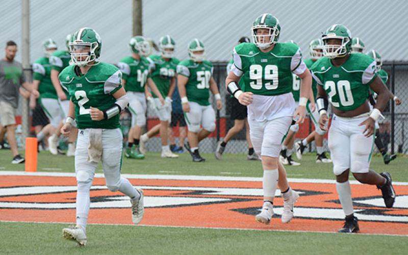 Chris Goode (No. 2), Keylan “Red” Rutledge (No. 99) and Jontavion “Jo Jo” Hughes (No. 20) lead the Franklin County Lions onto the field Saturday at Herndon Stadium for action in the Lake Hartwell Gridiron Classic football jamboree. (Photo by Scoggins)