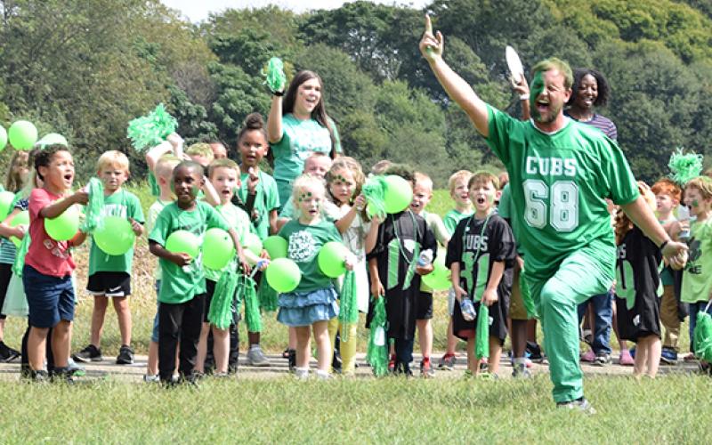 Lavonia Elementary School kindergarten teacher Tyler Matthews leads kindergartners in a cheer during Thursday's Lion Walk at Lavonia Elementary School. (Photo by Sinclair)