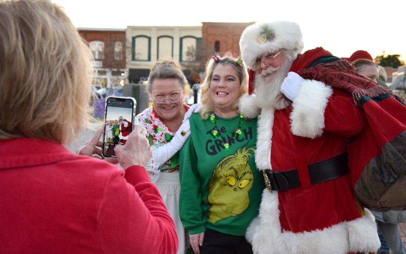 Gloria Allred takes a photo of Heather Bridges with Mrs. Claus and Santa Claus after his arrival in Lavonia for the city's tree lighting event. (Photo by Sinclair)