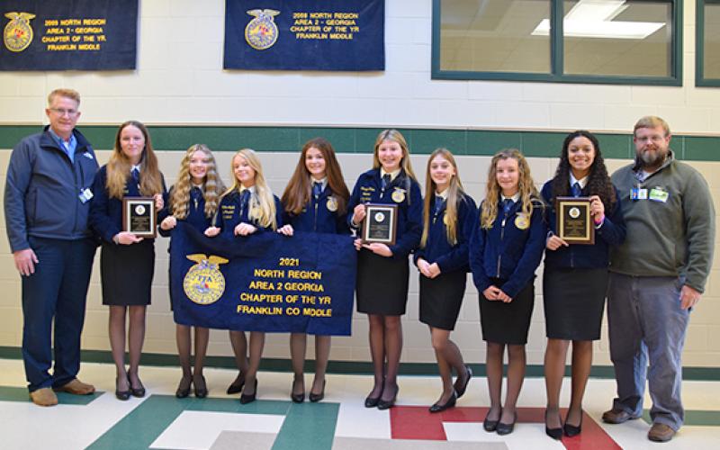 Kent Benson and Brian Elrick present Franklin County Middle School FFA officers Ava Gray, Rylie Sanders, Meghan Langley, Darby Roach, Camryn Childs, Scarlett Killen, Callie Walker, Ella Maisonneuve with the chapter’s 2021 Area 2 awards. (Photo by Sinclair)