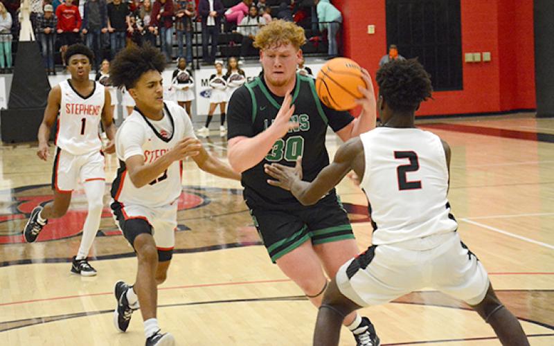 Senior Keylan “Red” Rutledge splits two Stephens County defenders on his way to two of his 10 fourth-quarter points that led Franklin County to a Region 8AAA-opening victory over Stephens County Friday in Toccoa. (Photo by Scoggins)