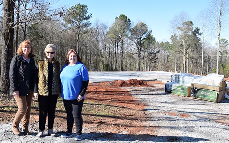 Director of Donor Relations and Fundraising Lucy Floyd, Founder and Executive Director Beverly Oxley, and Program Director Tanya Hipp show the progress made on the construction of the new facility for The Ark Family Preservation Center. Utilities were set, and lumber was waiting to start framing when weather permits. (Photo by Sinclair)
