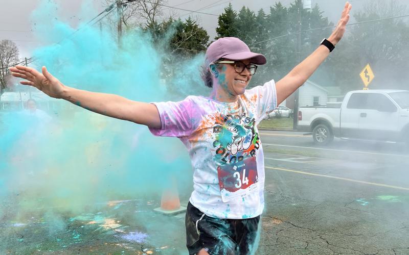 Nikki Gibson walks through a cloud of colored powder at the end of the Bulldog Color Run 5K and Fun Run Saturday at Lavonia Elementary School. (Photo courtesy of Lavonia Elementary School)