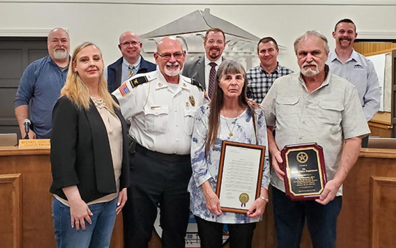 With the city council — Eddie Floyd, Michael Schulman, Mayor Courtney Umbehant, Jeremy Madden, and Andrew Murphy — supporting the honor, Police Chief Bruce Carlisle presents Lt. Scot Stowe’s widow, Crystal, and parents Mary and Gary with recognitions the Lavonia Police Department received because of Stowe’s efforts in capturing a fugitive. (Photo by Sinclair)