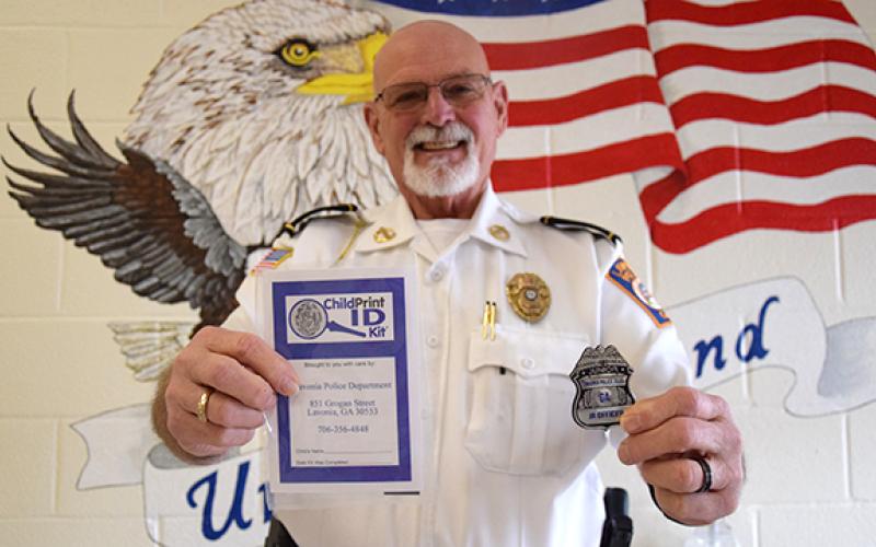 Lavonia Police Chief Bruce Carlisle shows the kit and junior officer badge that each student at Lavonia Elementary School will receive April 11. (Photo by Sinclair)
