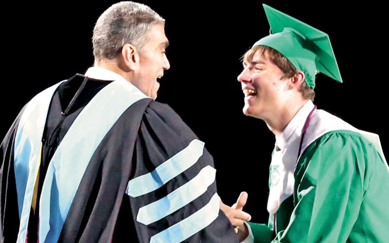 Franklin County School Superintendent Chris Forrer and son Christopher Jr. share a laugh after a big hug just before Chris presents his son his diploma from Franklin County High School during commencement exercises Friday night in Ed Bryant Stadium. (Photo by Scoggins)