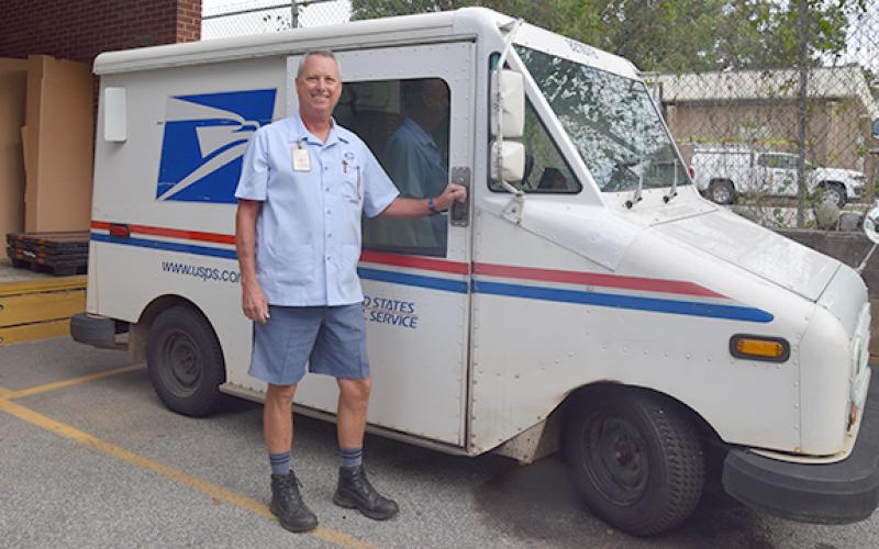 Mike Floyd stands in front of his mail truck before starting his route on his last day. (Photo by Sinclair)