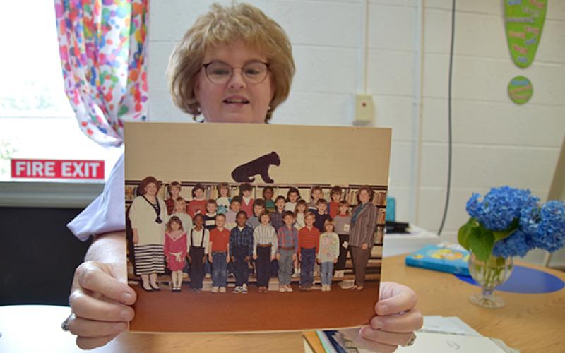 As she goes through her “forever file,” Robyn Moon finds the photo of the 28 “babies” in her first class of first graders. (Photo by Sinclair)