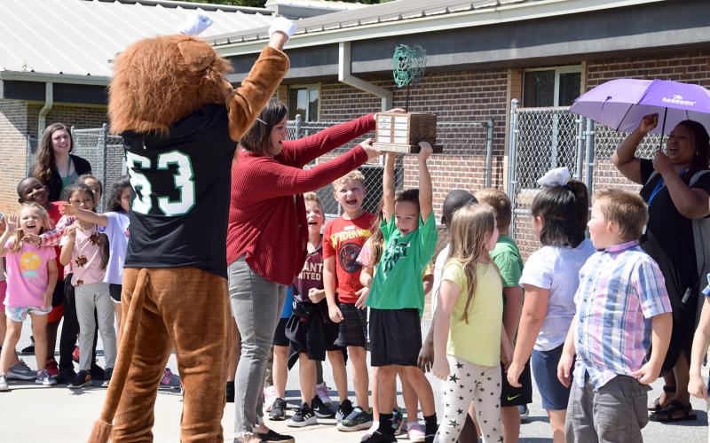 Assistant Principal Jamie Hammock helps Cahlil Holland hold up the Leo Cup during a ceremony Thursday at Lavonia Elementary School. (Photo by Sinclair)