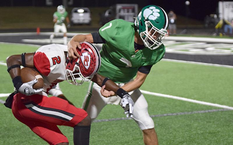 Lion Dee Oliver (No. 7) wrestles a Stephens County receiver to the ground. (Photo by Scoggins)