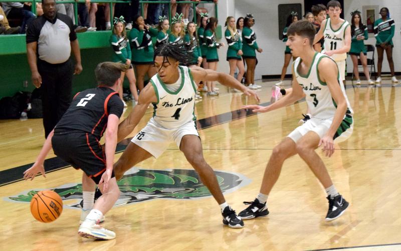 Jeloni Johnson (No. 4) and Cam Maxwell trap a Jackson County ballhandler during action Friday in the Lion’s Den. (Photos by Scoggins)