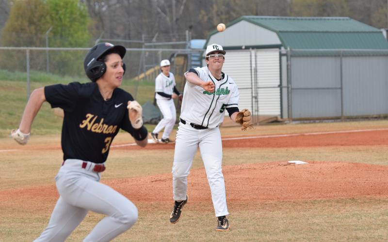 Duncan Beasley throws out a Hebron runner last week in 8AAA action. (Photos by Scoggins)