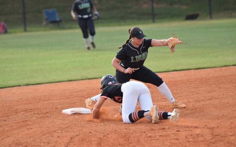 Senior Karson Johnson (left photo) smiles while standing on second after a double Tuesday against Hart County. Junior McCall Davis (right photo) delivers a pitch. (Photos by Scoggins)