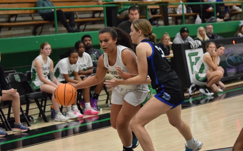 Kallie Thrift dribbles past an Oconee County defender during action Tuesday in the Lion’s Den.