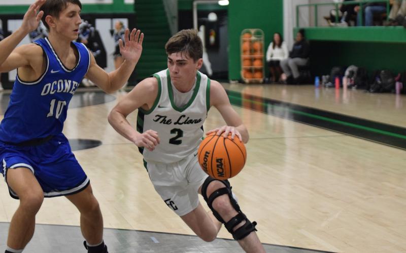 Carson Coulter drives past an Oconee defender Tuesday on his way to two of his 10 points in a Franklin County victory.