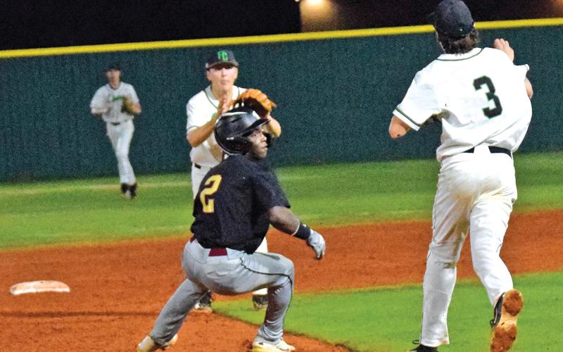 Easton Gailey and Luke Beasley (above) catch a Hebron runner in a rundown during Region 8AAA action Monday at FCHS.