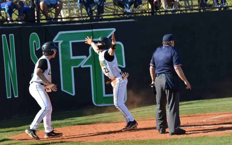 Easton Gailey and Keilin Sanders celebrate after Sanders scored a run in recent region action at FCHS.
