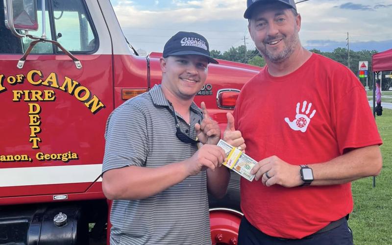 Jacob Tompkins (left) receives the $1,000 grand prize for winning the Canon Fire Department’s Touch the Truck event. Canon Fire Chief Lee Williams (right) presented the prize.