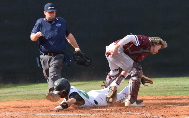 Senior Keilin Sanders slides safely between the legs of the Dawson County catcher to score in a second round state playoff series Monday in Carnesville. (Photos by Scoggins)