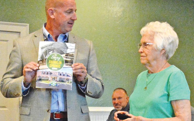 Franklin Springs Mayor Lee Moore presents Emily Phillips with the first commemorative coin and updated history book at Monday’s Franklin Springs City Council Meeting, which was called to commmerate the city’s 100th anniversary. Phillips was recognized as the oldest citizen in the city. (Photo by Eavenson)