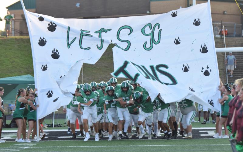 CARNESVILLE – The Franklin County Lions busts through a banner Friday night before its preseason scrimmage against Madison County at Jeff Davis Field at Ed Bryant Stadium. The season opener for the Lions will be this Friday at FCHS against  the Chestatee War Eagles. Kickoff will be at 7:30 p.m. For a complete preview of the Lions football team, band and cheerleaders, see this year’s issue of Franklin Friday Nights inside this week. (Photo by Scoggins)