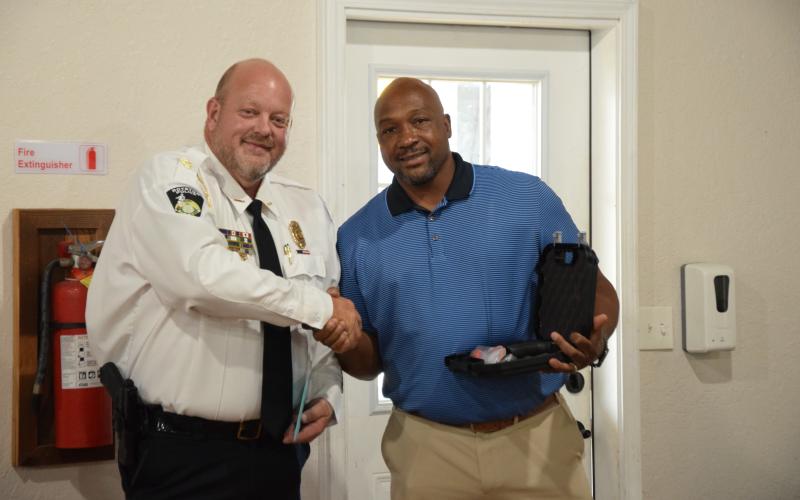 Royston Mayor Keith Turman (right) presents retiring Police Chief Donnie Bolemon (left) with a gift and his service weapon Tuesday during a reception. (Photo by Scoggins)